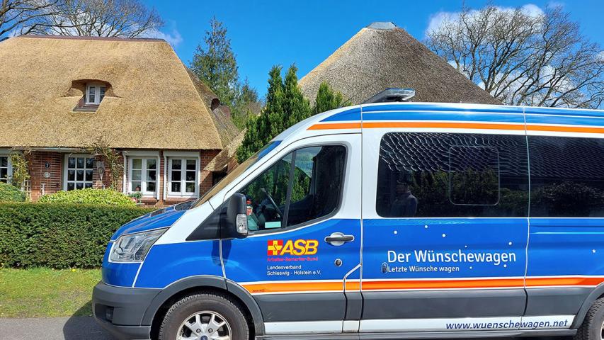 Der ASB-Wünschewagen Schleswig-Holstein vor dem Reetdachhaus